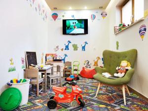 シュクラルスカ・ポレンバにあるVacationClub - Osiedle Podgórze 1B Apartament 16のおもちゃのオートバイとテレビ付きの子供部屋