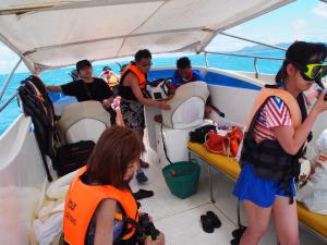 a group of people standing in the back of a boat at Runa Group House Samed in Ko Samed