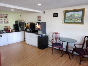 a room with a table and chairs and a kitchen at Sea Girt Lodge in Sea Girt