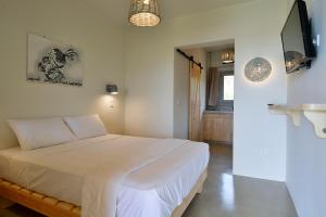 a bedroom with a white bed and a window at Rooster Guesthouse Rooms in Kipri
