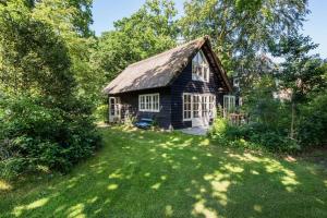 une petite maison avec un toit de chaume dans une cour dans l'établissement Unique Atelier in Bergen, à Bergen