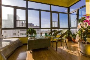 a room with a bed and a table and some windows at Wuwei Qiyou Space Capsule Hostel in Wuwei