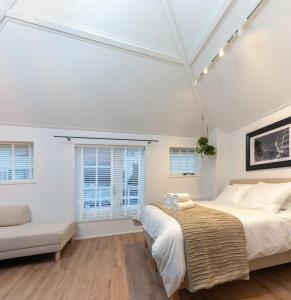 a bedroom with a bed and a couch and windows at Design City Center Family double floor apartment studio Delft C38 in Delft