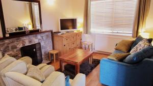 a living room with a couch and a fireplace at 8B Calbost in Calbost