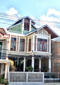a house with white trim and red windows at Thaimueang Boutique Hotel in Thai Muang