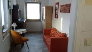 een woonkamer met een rode bank, een tafel en een raam bij Rennsteigwohnung Rust in Schmiedefeld am Rennsteig