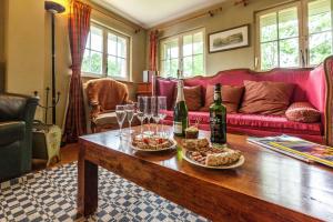 ein Wohnzimmer mit einem Tisch mit Speise- und Weingläsern in der Unterkunft La maison du lac in Cul-des-Sarts