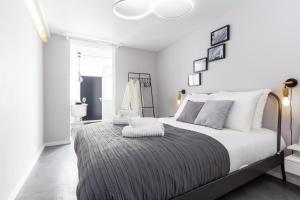 a white bedroom with a large bed with a gray blanket at Original twin Studio Delft City Central Station 30B in Delft