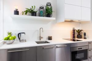 a kitchen with white cabinets and stainless steel appliances at Original twin Studio Delft City Central Station 30B in Delft +8 photos