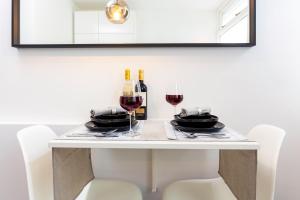 a table with two glasses of wine and a mirror at Original twin Studio Delft City Central Station 30B in Delft