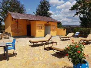 ein Gebäude mit einer Gruppe von Stühlen und einer Terrasse in der Unterkunft Tan-Swiss Lodge in Mikumi