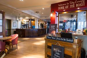 ein Restaurant mit Tisch und Stühlen und ein Geschäft in der Unterkunft Toby Carvery Hull by Innkeeper's Collection in Hull