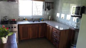 a kitchen with wooden cabinets and a sink and a window at Bosysol en las sierras in Merlo