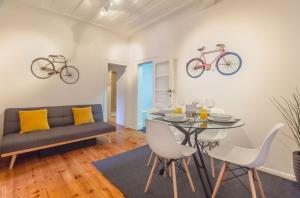 - un salon avec une table et 2 vélos sur le mur dans l'établissement Lisbon City Stay @ Largo do Carmo, à Lisbonne