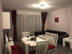 バンスコにあるPredela 1 Bansko Apartmentの白いテーブルと椅子、ソファが備わる客室です。