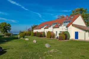 una casa bianca con il tetto rosso di Apartment Biber mit Terrasse a Dewichow