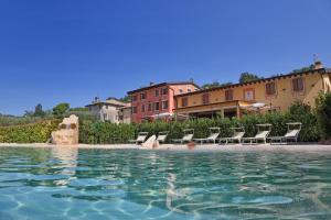 ein Wasserbecken mit Stühlen und Gebäuden im Hintergrund in der Unterkunft La Zerla in Bardolino