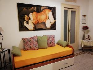 ナポリにあるCasa Lillina a Toledo , near Piazza del plebiscitoの壁に絵画が描かれたソファ付きの部屋