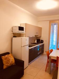 a kitchen with a white refrigerator and a microwave at appartamenti vespucci 16 in Bardolino
