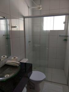 a bathroom with a toilet and a sink and a mirror at Hotel Costa do Delta in Tutóia