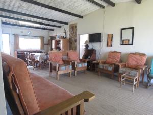 uma sala de estar com um monte de cadeiras e uma mesa em Bare Foot Cottage em Hole in the Wall