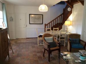een woonkamer met een trap en een tafel en stoelen bij Le Clos Mony in Chenonceaux