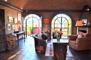 サンミゲル・デ・アジェンデにあるCasa de la Cuesta B&Bの椅子とテーブルと窓のあるリビングルーム