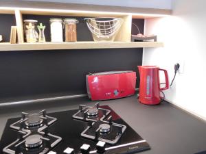 a kitchen counter with a stove and a red appliance at New cosy apartment near Arena in Zagreb