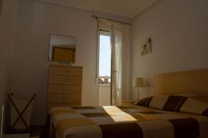 a bedroom with a bed and a dresser and a window at Ribera Beach 1 Apartment Elisa in Mar de Cristal