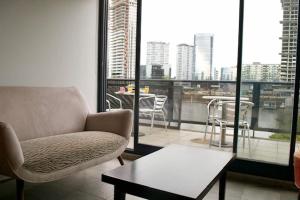 a living room with a couch and a table and a balcony at Puerto Madero Apart in Buenos Aires