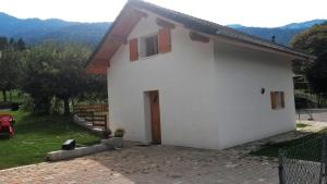 a white house with a door and mountains in the background at le velan in Giez
