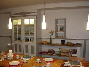 una cocina con una mesa de madera con platos. en Maison Fouga, en Cadéac