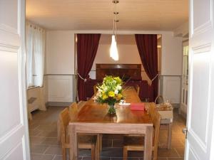 a dining room table with a vase of flowers on it at Maison Fouga in Cadéac