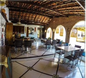 una stanza con tavoli e sedie in un edificio di Pousada Lua Estrela a Canoa Quebrada