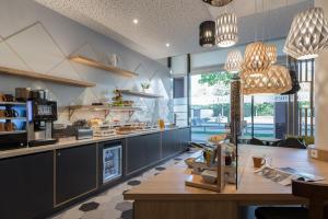 a kitchen with a table and a large window at Citadines Arnulfpark Munich in Munich