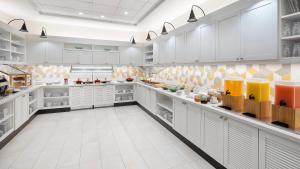 uma grande cozinha branca com armários brancos e prateleiras em Hyatt Place Jacksonville St. Johns Town Center em Jacksonville