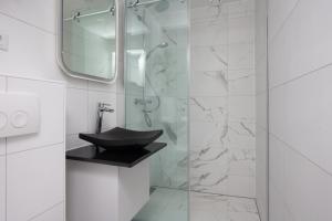 a bathroom with a sink and a glass shower at Design City Center Family double floor apartment studio Delft C38 in Delft