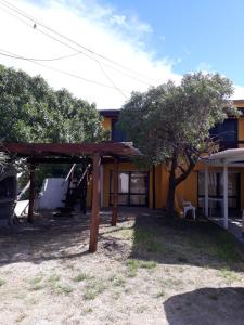 una casa con un refugio de madera en el patio en La Casa del Caminante, en Aguas Dulces