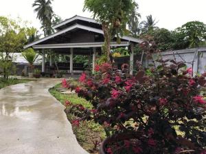 a building with pink flowers in front of a walkway at Thaimueang Boutique Hotel in Thai Muang