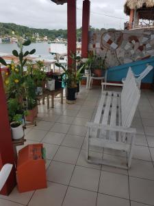 een witte bank op een patio met planten bij Hotel Posada Tayazal in Flores