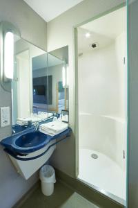 y baño con lavabo azul y ducha. en ibis budget Haguenau Strasbourg Nord, en Haguenau