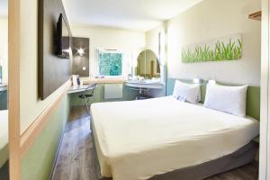 a hotel room with a bed and a sink at ibis budget Haguenau Strasbourg Nord in Haguenau