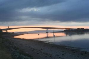 a bridge over a body of water at sunset at Skye View in Glenelg