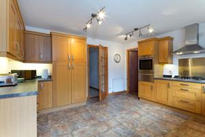 a large kitchen with wooden cabinets and appliances at Skye View in Glenelg