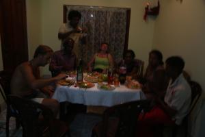 a group of people sitting around a table with food at Grand Nest Bay Resort in Weligama