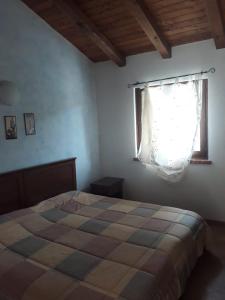 1 dormitorio con cama y ventana en Taverna del Dolmen, en Millesimo