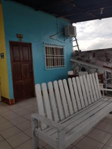 una panca di legno seduta di fronte a un edificio blu di Hotel Posada Tayazal a Flores