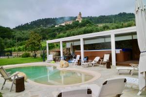 a swimming pool with chairs and a house at Agriturismo Ada Musso ss in Diano Borello