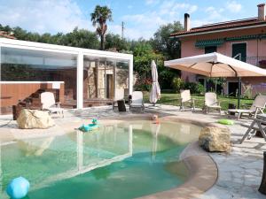 a swimming pool in a yard with chairs and a house at Agriturismo Ada Musso ss in Diano Borello