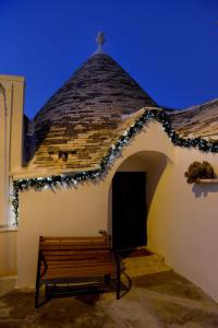 a building with a bench and a roof with lights at Trullo Assenzio in Alberobello